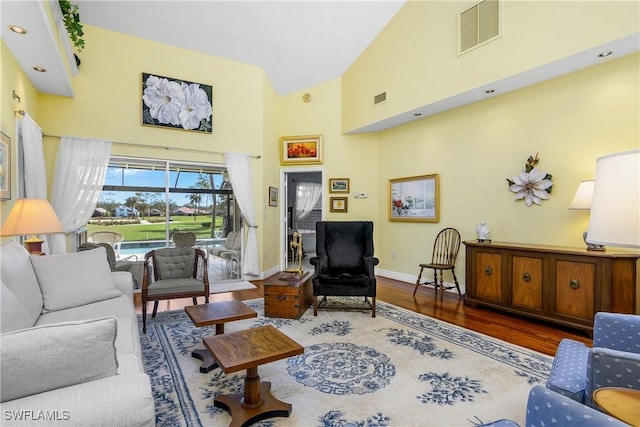 living room featuring wood-type flooring and high vaulted ceiling