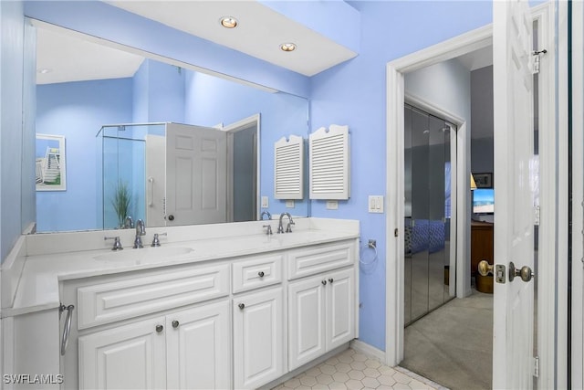 bathroom featuring a shower with door and vanity