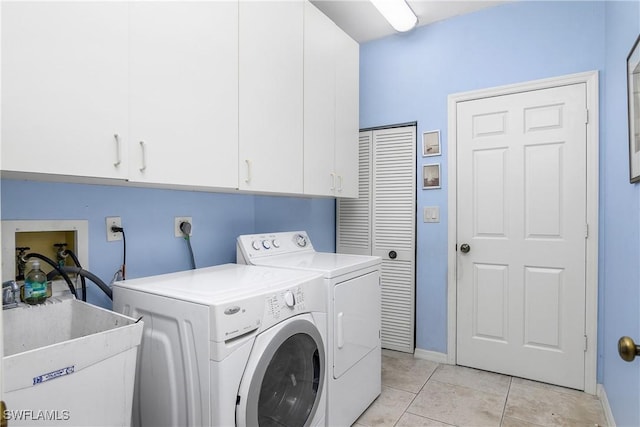 washroom featuring cabinets, sink, washer and dryer, and light tile patterned floors