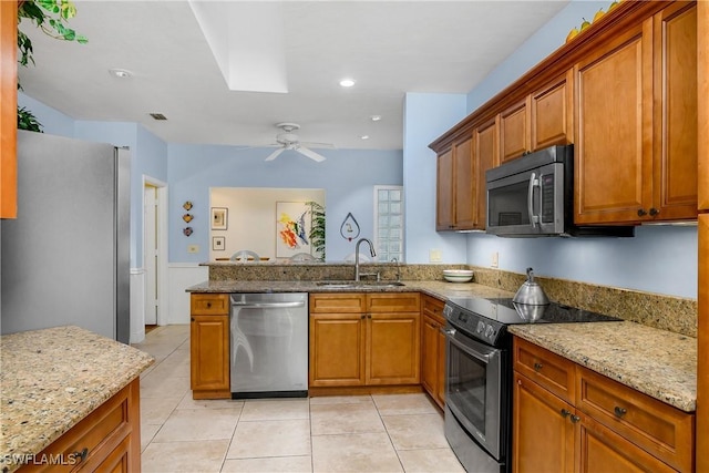 kitchen featuring sink, light stone counters, light tile patterned floors, ceiling fan, and stainless steel appliances