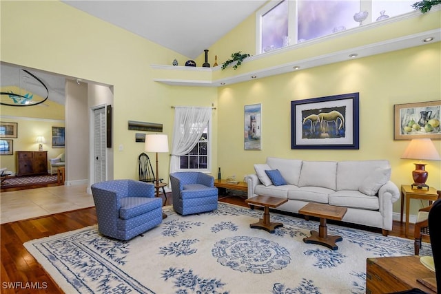 living room with hardwood / wood-style flooring and high vaulted ceiling