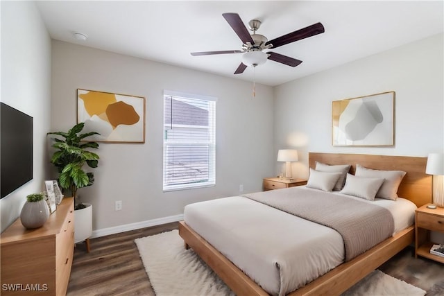 bedroom with dark wood-type flooring, a ceiling fan, and baseboards