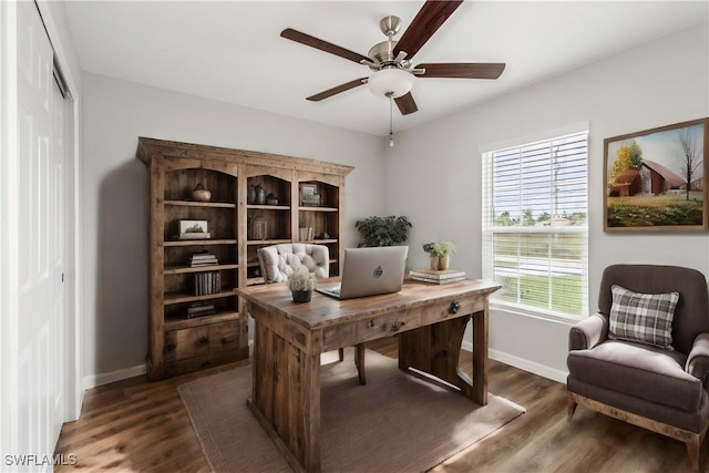 office area with dark wood-style flooring, a ceiling fan, and baseboards