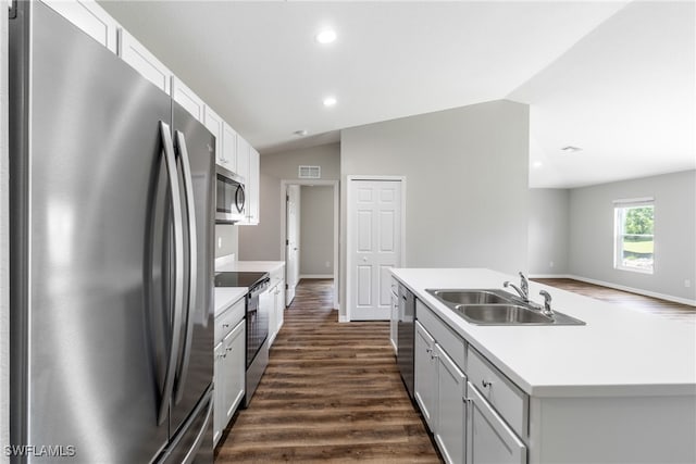 kitchen with lofted ceiling, a kitchen island with sink, stainless steel appliances, a sink, and light countertops