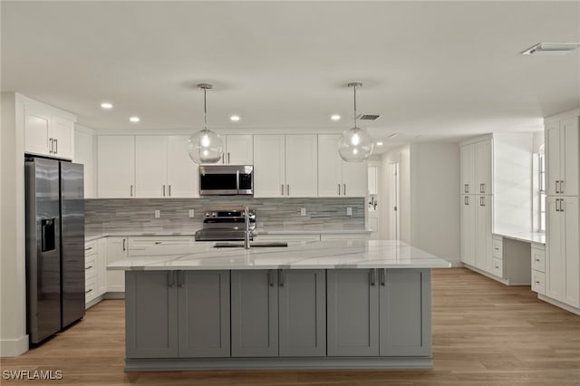 kitchen with light wood finished floors, visible vents, appliances with stainless steel finishes, white cabinets, and a sink