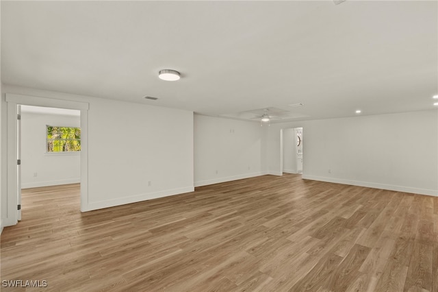 spare room with a ceiling fan, baseboards, visible vents, and light wood finished floors