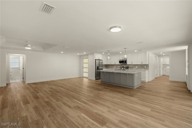 kitchen featuring stainless steel appliances, open floor plan, visible vents, and white cabinetry