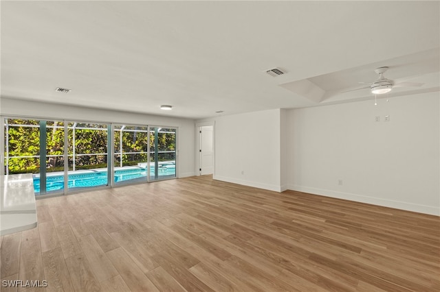 empty room featuring baseboards, visible vents, and light wood-style floors