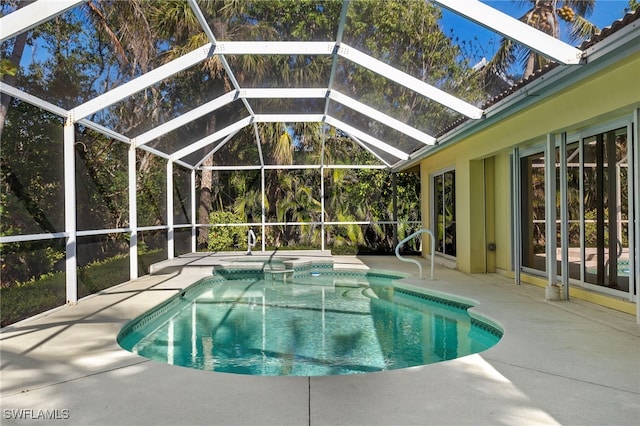 view of swimming pool with a pool with connected hot tub, a patio area, and a lanai