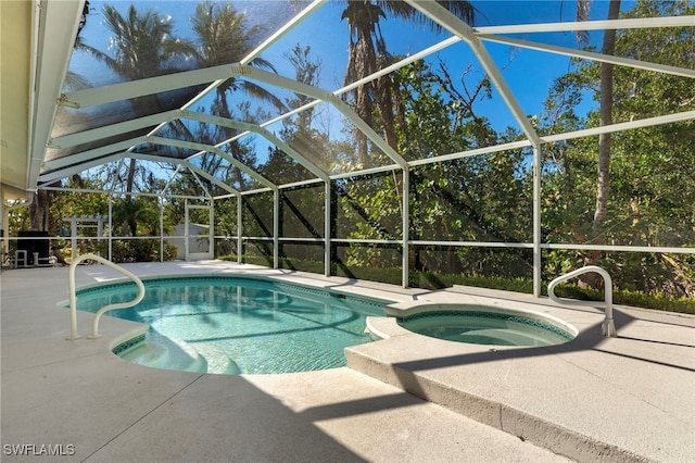 view of pool featuring a lanai, a patio area, and a pool with connected hot tub