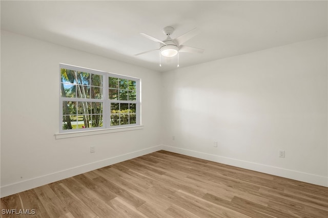 empty room with baseboards, a ceiling fan, and light wood-style floors