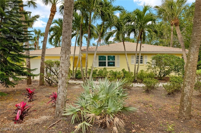 single story home with a tile roof and stucco siding