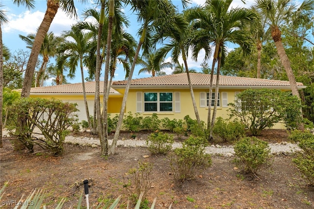 single story home with a tile roof and stucco siding