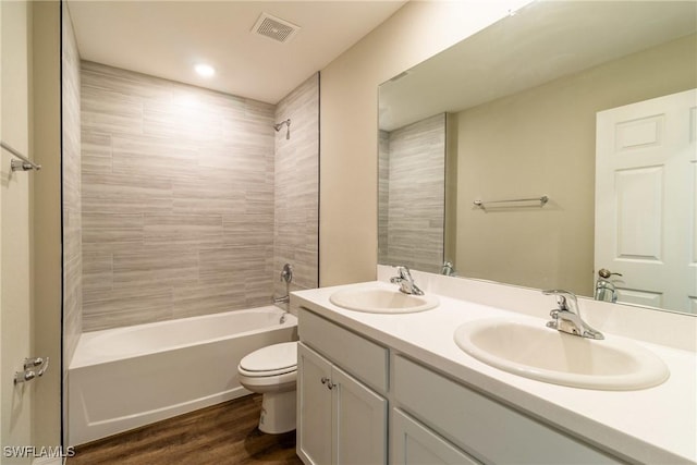 bathroom with toilet, visible vents, a sink, and wood finished floors