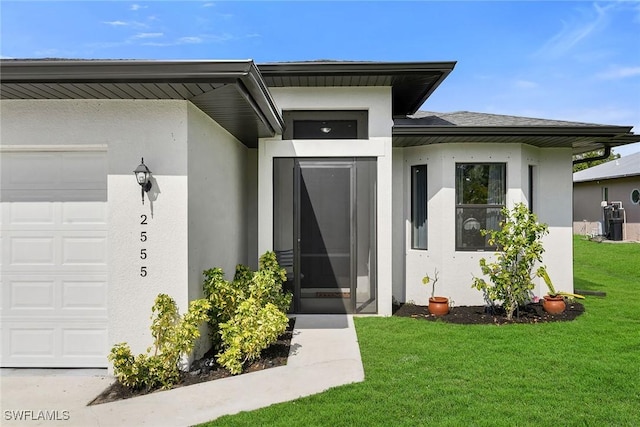 entrance to property with a garage and a yard