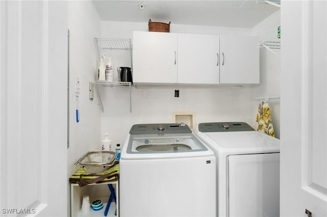 laundry area featuring separate washer and dryer and cabinet space