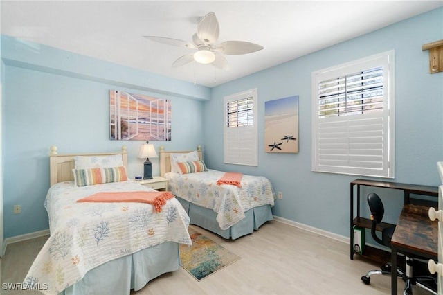 bedroom with light wood finished floors, baseboards, and a ceiling fan