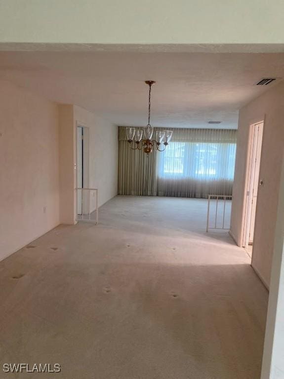 unfurnished dining area featuring a notable chandelier and light colored carpet