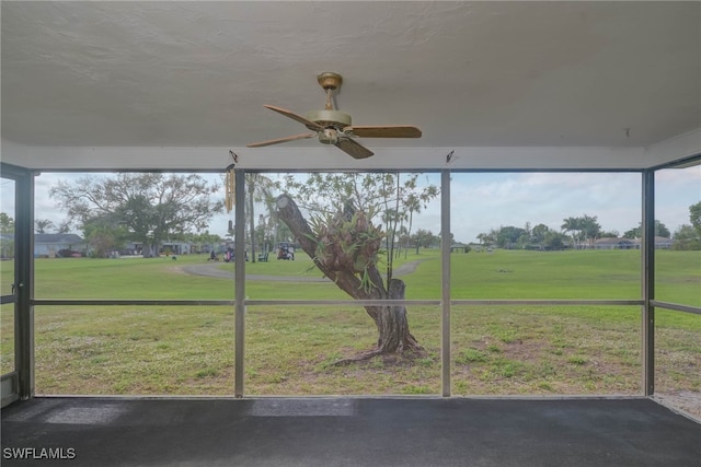 unfurnished sunroom featuring a ceiling fan