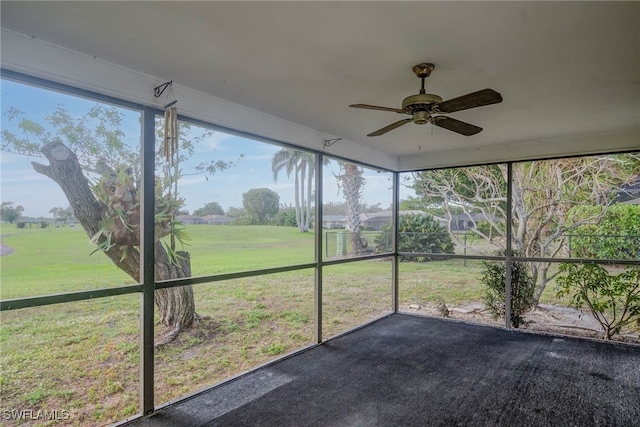 unfurnished sunroom with ceiling fan