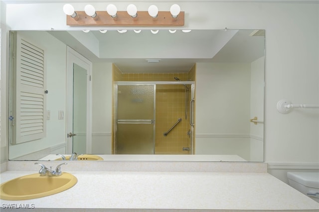 bathroom featuring a shower stall, toilet, and vanity