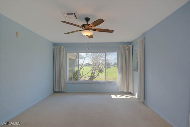 unfurnished room with a ceiling fan, visible vents, and light carpet