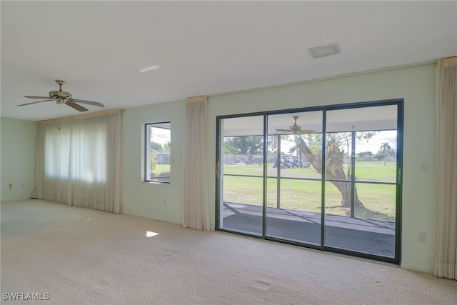 spare room with light carpet and a ceiling fan