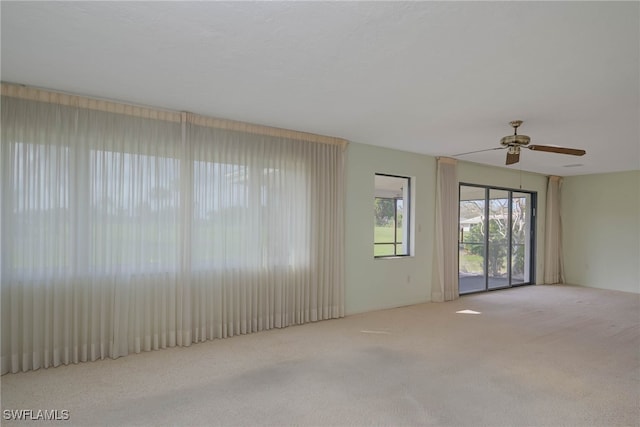 empty room featuring light colored carpet and ceiling fan