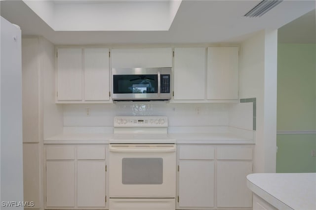 kitchen featuring light countertops, white cabinets, white range with electric cooktop, and stainless steel microwave