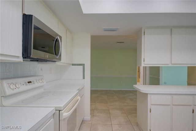 kitchen featuring light countertops, visible vents, white cabinets, stainless steel microwave, and white electric stove