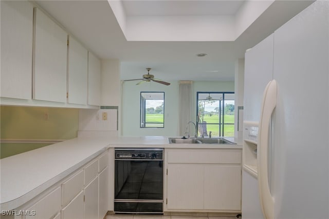 kitchen featuring light countertops, black dishwasher, white cabinets, a sink, and white fridge with ice dispenser