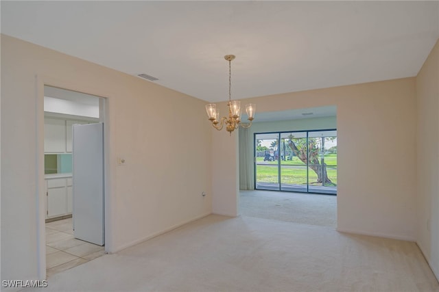 empty room with light colored carpet, a notable chandelier, visible vents, and baseboards