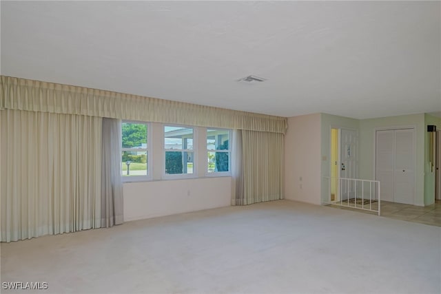 spare room with visible vents and light carpet