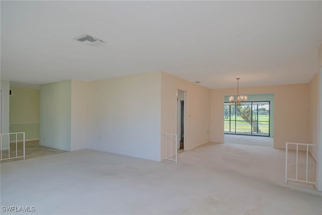 unfurnished room featuring visible vents, a chandelier, and light colored carpet