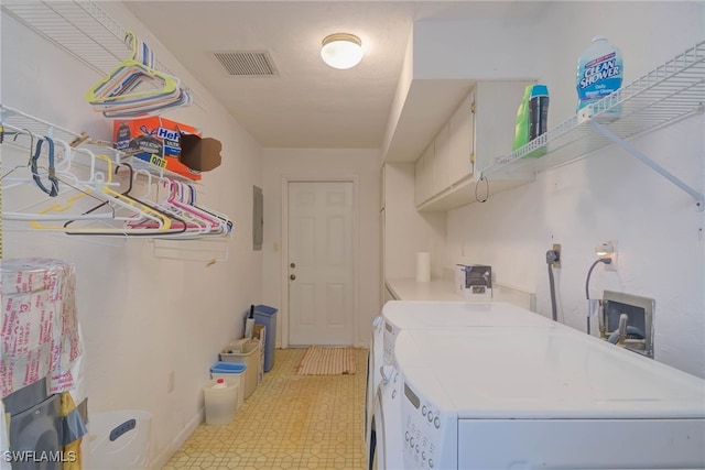 clothes washing area with electric panel, visible vents, separate washer and dryer, laundry area, and light floors