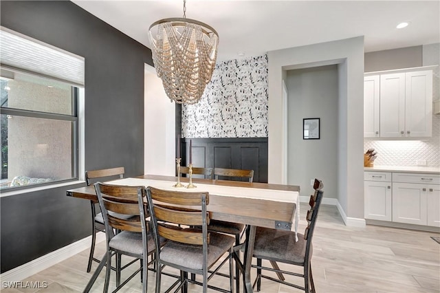 dining area with light wood finished floors, baseboards, a chandelier, and recessed lighting