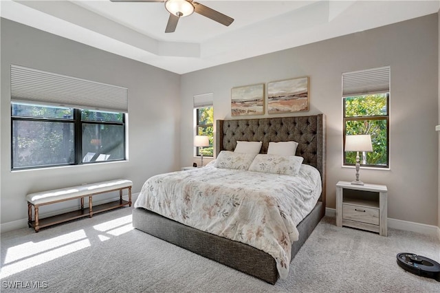 bedroom featuring carpet floors, a ceiling fan, baseboards, and a tray ceiling