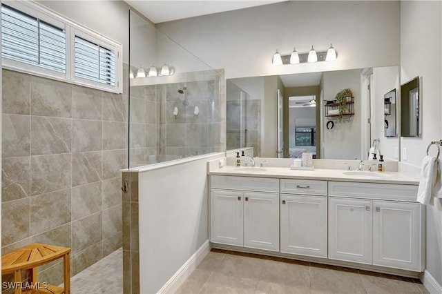 bathroom with double vanity, walk in shower, a sink, and a ceiling fan