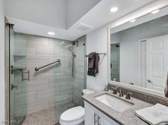 bathroom with vanity, toilet, and a shower with shower door