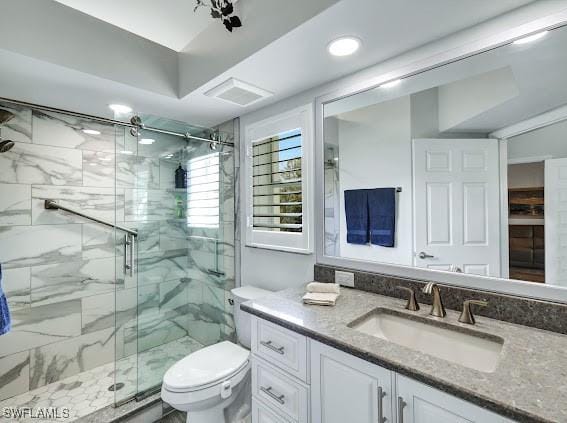 bathroom with vanity, a shower with shower door, and toilet