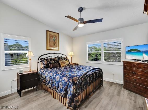 bedroom featuring ceiling fan, lofted ceiling, and light wood-type flooring