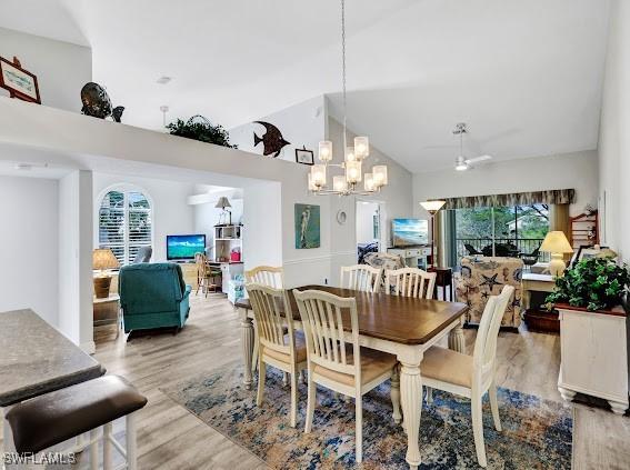 dining area featuring vaulted ceiling, ceiling fan, and light wood-type flooring