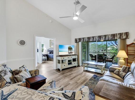 living room featuring ceiling fan, wood-type flooring, and high vaulted ceiling