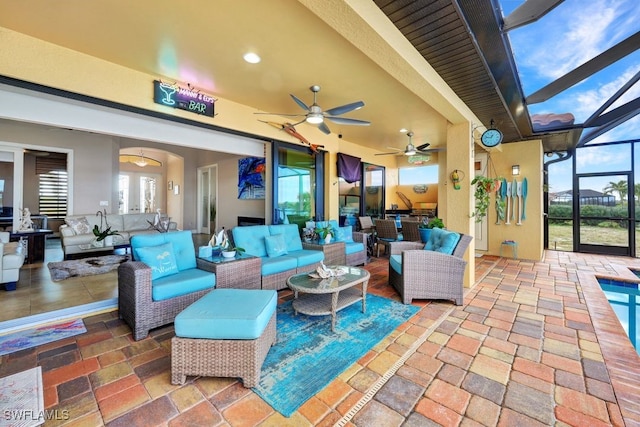 view of patio featuring ceiling fan, outdoor lounge area, and glass enclosure