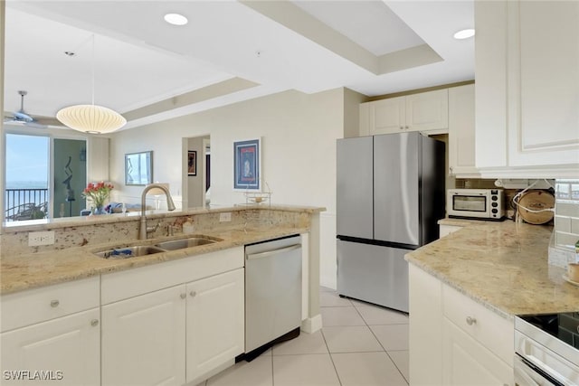 kitchen with white cabinetry, sink, a tray ceiling, and stainless steel appliances