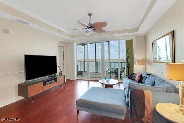 living room with ornamental molding, hardwood / wood-style floors, ceiling fan, and a tray ceiling