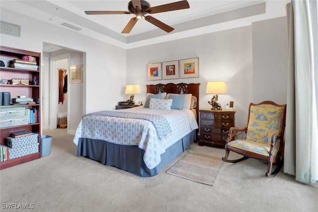 carpeted bedroom featuring crown molding, ceiling fan, and a tray ceiling