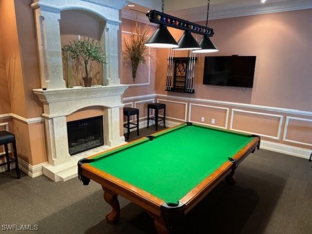 rec room featuring dark colored carpet, crown molding, pool table, and a fireplace