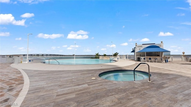 view of pool with a patio area, a hot tub, and an outdoor bar