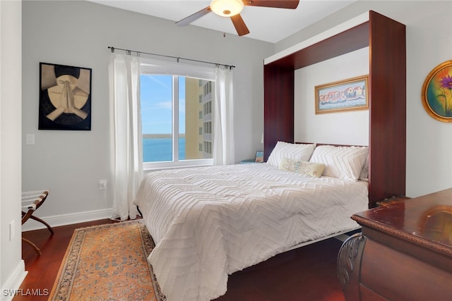 bedroom with ceiling fan, a water view, and dark hardwood / wood-style flooring